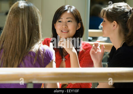 Tre amici in un centro commerciale food court Foto Stock