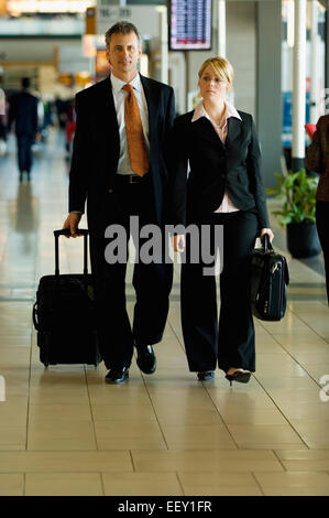 Due uomini di affari che in un aeroporto Foto Stock