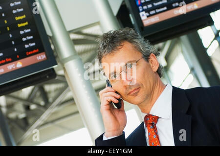 Imprenditore in aeroporto utilizzando assistente digitale personale Foto Stock