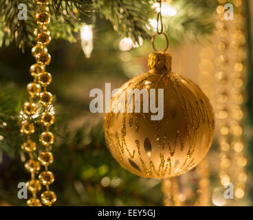 Le decorazioni di Natale su di un albero di Natale illuminato da luci Foto Stock