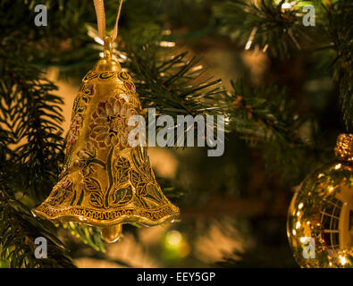 Primo piano delle decorazioni natalizie su un albero di Natale illuminato da luci Foto Stock