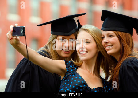 Tre amici alla cerimonia di consegna dei diplomi Foto Stock