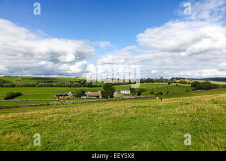 2 persone camminare sotto cieli blu e nuvole bianche in estate vicino al luogo di prato Grange Over Haddon Derbyshire England Regno Unito Foto Stock