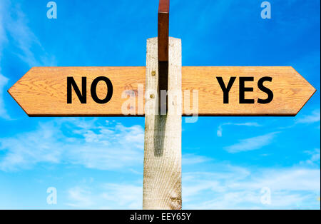 Indicazioni del cartello in legno con due frecce opposte oltre il cielo blu chiaro, Sì e No messaggi, decisionale immagine concettuale Foto Stock