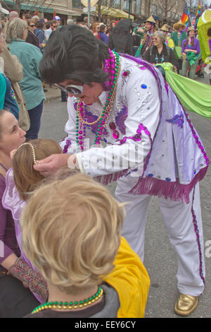 Un uomo in un colorato costume Elvis dà Mardi Gras perle per i bambini durante la primavera Mardi Gras Parade di Asheville, NC Foto Stock