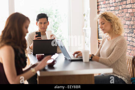 Amici in seduta cafe, utilizzando i notebook e tablet digitale Foto Stock