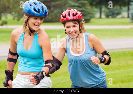 Due donne il pattinaggio in linea a un parco Foto Stock