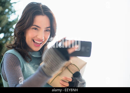 Giovane donna prendendo selfie con telefono mobile Foto Stock