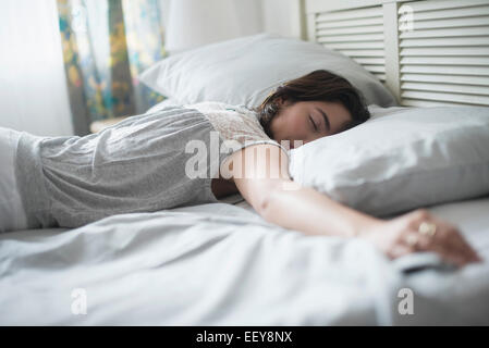 Donna che dorme nel letto Foto Stock