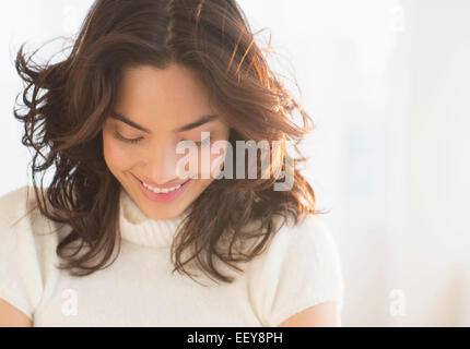 Sorridente bruna giovane donna che guarda in basso Foto Stock