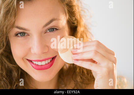 Giovane donna di applicare il make up foundation Foto Stock