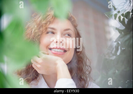 Sorridente giovane donna fantasticando Foto Stock