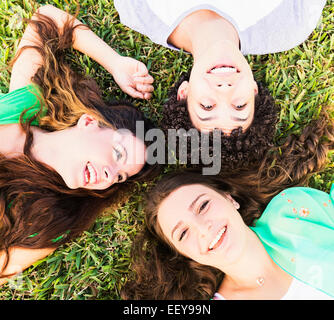 Ritratto di amici (14-15) giacenti sull'erba Foto Stock