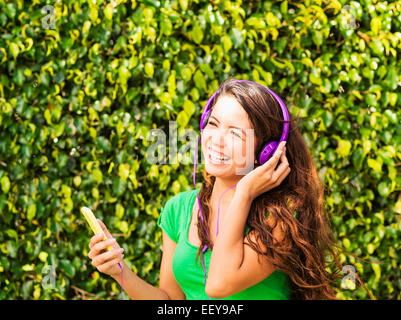 Giovane donna ascoltando musica e ridere Foto Stock