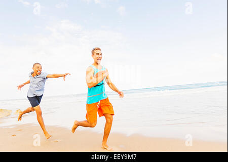 Stati Uniti d'America, Florida, Giove, giovani uomini giocando con il calcio sulla spiaggia Foto Stock