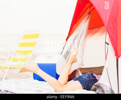 Giovane donna per le gambe fuori dalla tenda Foto Stock
