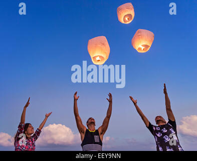 I giovani con lanterne illuminate al tramonto Foto Stock