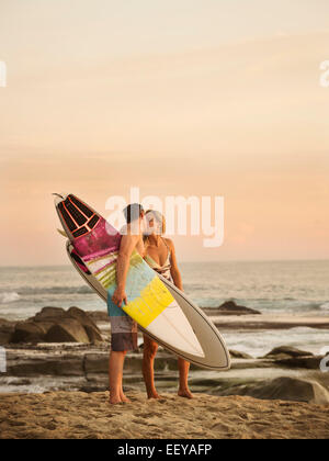 Stati Uniti, California, Laguna Beach, Mid-adulto giovane baciare sulla spiaggia al tramonto Foto Stock