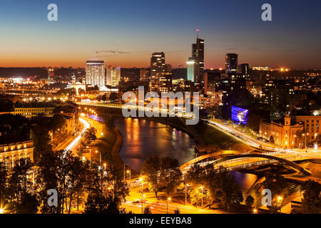 La Lituania, Vilnius, illuminato riverfront cityscape visto da di elevazione sulla riva opposta Foto Stock