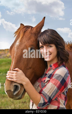 Ragazza in piedi accanto a un cavallo Foto Stock