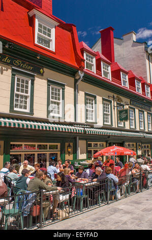 QUEBEC City, Quebec, Canada - persone mangiare e bere a tavoli all aperto di fronte all'Auberge du Tresor hotel e ristorante Foto Stock