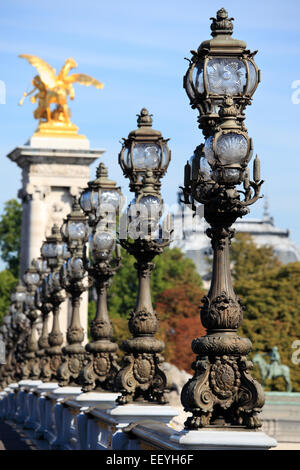 Ornate renaissance lampade stradali sul famoso Pont ponte Alexandre III nel centro di Parigi con il Petit Palais in distanza. Foto Stock