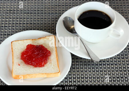 Confettura di fragole sul pane e la tazza di caffè Foto Stock