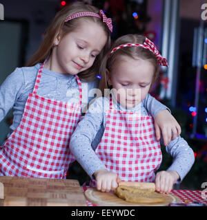 Bambine in muffole di Natale cottura gingerbread cookie Foto Stock