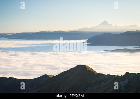 Panorama mozzafiato al tramonto sul italiano delle Alpi occidentali con M. Viso picco in background e le nuvole che coprono le valli Foto Stock