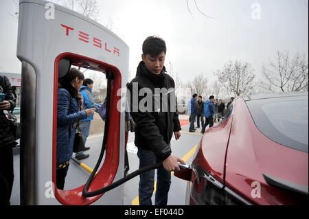 Tianjin. 24 gen 2015. Uno staff per la ricarica di una Tesla auto elettrica in corrispondenza di una stazione di sovralimentazione nel nord della Cina di Tianjin, Gennaio 24, 2015. La prima Tesla Supercharger stazione di Tianjin è stato messo in uso il sabato. I compressori sono tra i più veloci del mondo dei sistemi di ricarica, consentendo agli utenti di ricaricare completamente le loro vetture Tesla' delle batterie in 75 minuti. © Zhang Chenlin/Xinhua/Alamy Live News Foto Stock