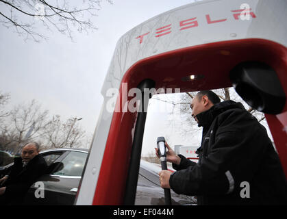 Tianjin. 24 gen 2015. Un personale prepara per ricaricare una Tesla auto elettrica in corrispondenza di una stazione di sovralimentazione nel nord della Cina di Tianjin, Gennaio 24, 2015. La prima Tesla Supercharger stazione di Tianjin è stato messo in uso il sabato. I compressori sono tra i più veloci del mondo dei sistemi di ricarica, consentendo agli utenti di ricaricare completamente le loro vetture Tesla' delle batterie in 75 minuti. © Zhang Chenlin/Xinhua/Alamy Live News Foto Stock