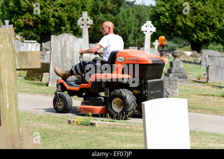 Uomo alla guida di sit-sui tosaerba a promuovere Hill Road cimitero, Bedford, Bedfordshire, Inghilterra Foto Stock