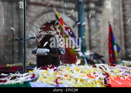 La Paz, Bolivia, 24 gennaio 2015. Un'antica illa (o statua) di un Ekeko (un dio Aymara dell'abbondanza) è vista di fronte alla chiesa di San Francisco e alle bandiere dei wiphala mentre viene sfilata per le strade di la Paz per celebrare la sua prima apparizione al festival Alasitas, che inizia oggi. La statua ha circa 2000 anni ed è stata realizzata dalla cultura Pucara. È stato portato dal sito archeologico di Tiwanaku in Svizzera nel 1858, e restituito in Bolivia dal Museo di storia di Berna nel novembre 2014. Credito: James Brunker / Alamy Live News Foto Stock