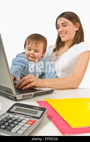 La madre e il bambino a giocare con il computer portatile Foto Stock