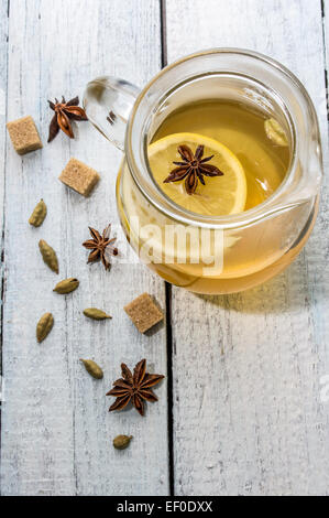 Tè al limone con il cardamomo e anice stellato su una tavola di legno Foto Stock