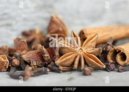 Stella di anice, bastoncini di cannella e chiodi di garofano sul vecchio legno grigio Foto Stock