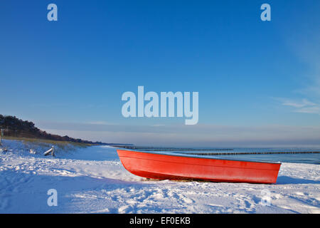 Rosso barca sulla riva del Mar Baltico in inverno Foto Stock