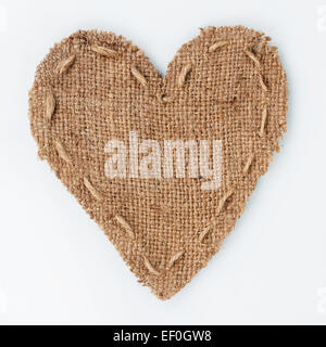 Cuore simbolico di tela ruvida giace su uno sfondo bianco, con posto per il testo Foto Stock