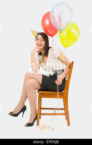 Donna che indossa cappellino e palloncini di contenimento Foto Stock