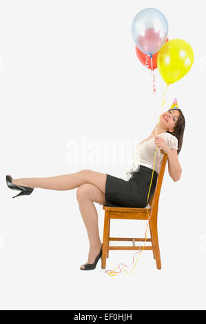 Donna che indossa cappellino e palloncini di contenimento Foto Stock