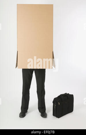Imprenditore con una scatola di cartone sopra la sua testa Foto Stock