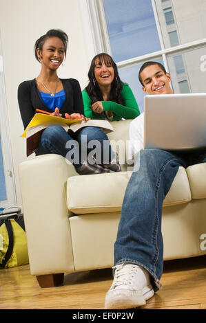 Tre persone a ridere mentre riuniti intorno al lettino Foto Stock
