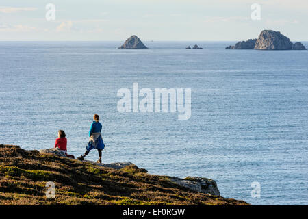 Due escursionisti femmina guarda verso il mare, Crozon Penisola, Finisterre, Bretagna Francia Foto Stock