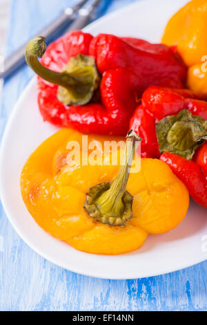 Carni arrosto di peperoni rossi e gialli su piastra bianca, il fuoco selettivo Foto Stock