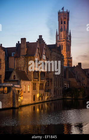 Belfort-Hallen torre campanaria dal canale in corrispondenza di Rozenhoedkaai accesa fino al crepuscolo, Bruges, Belgio Foto Stock