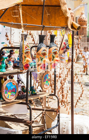 Tipico vivacemente colorato tradizionali maschere viso e altro artigianato locale su una strada di stallo del mercato per la vendita di souvenir turistici, Trinidad, Cuba Foto Stock