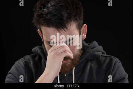 Preoccupato per il pizzetto Giovane con mano sul viso Foto Stock