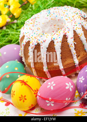 Torta di Pasqua e uova colorate Foto Stock