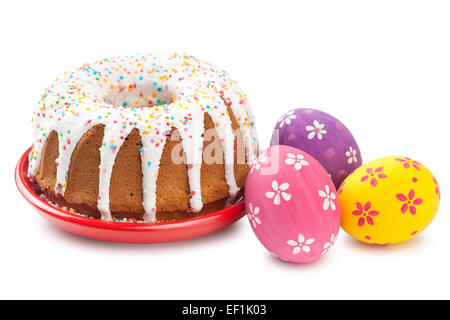 Torta di Pasqua e uova colorate su bianco Foto Stock