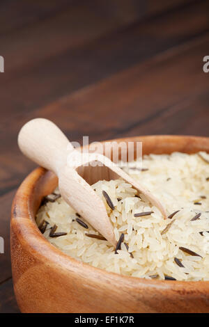 Il bianco e il riso selvatico nella ciotola di legno sul tavolo da cucina Foto Stock